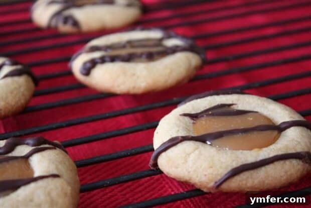 Espresso Caramel Thumbprint Delights 2 Caramel Macchiato Thumbprint Cookies drizzled with chocolate on a festive cookie tray, perfectly embodying a holiday dessert