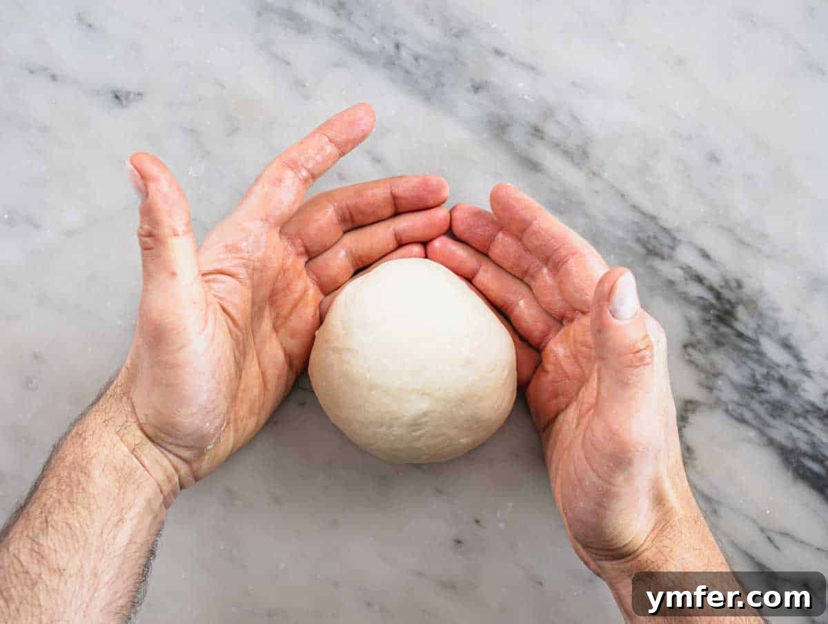 Perfect Ooni Pizza Dough Formula 24 rolling the dough balls on the marble worktop