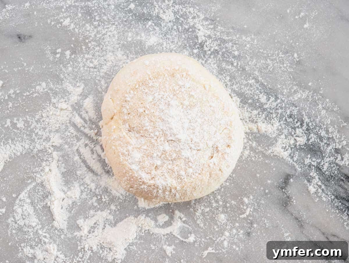Perfect Ooni Pizza Dough Formula 27 pizza dough on a worktop with flour