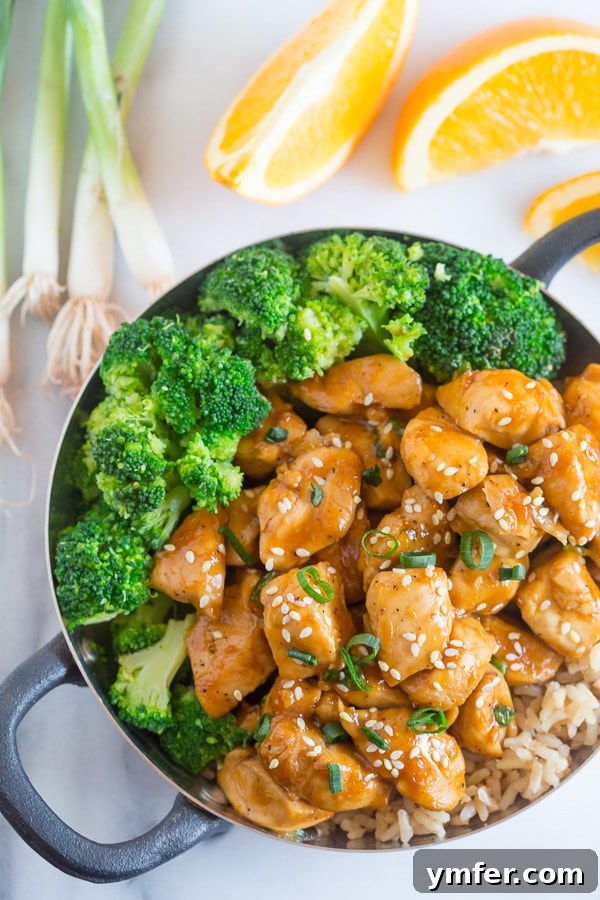 This 20 minute healthier orange chicken is the perfect weeknight dish. Why pay for take out when you can make this quick and easy dish from scratch. Healthier Orange Chicken presented in a deep round bowl, garnished, highlighting its homemade appeal.