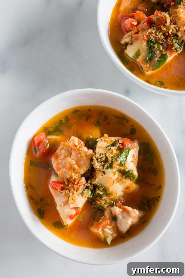 20 Minute Ocean Stew 2 A steaming bowl of 20-minute seafood stew with cod and shrimp in a tomato-garlic-herb broth, garnished with fresh herbs.