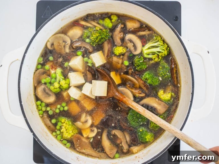 Healthy Asian Kitchen 35 vegetables and tofu cubes in a Dutch oven