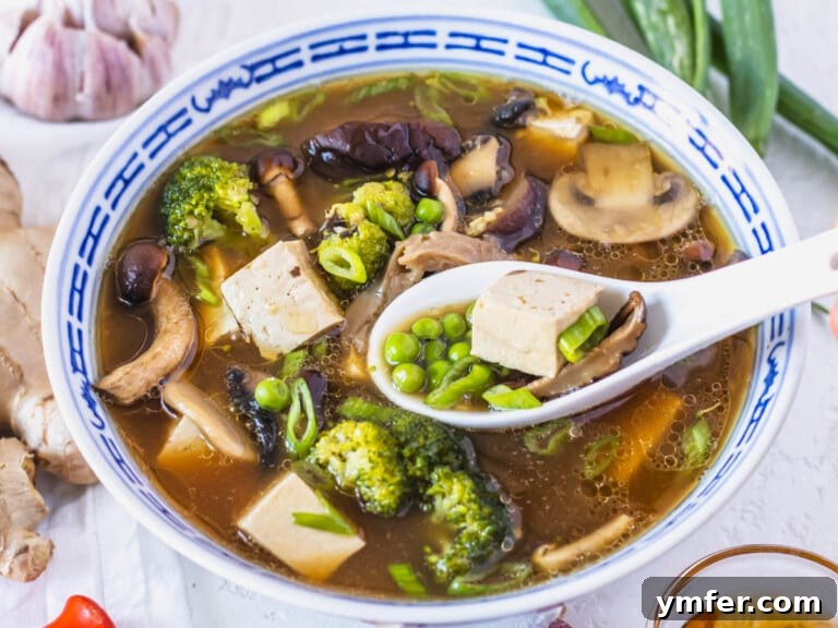 Healthy Asian Kitchen 37 Tofu soup with peas, broccoli and a white spoon