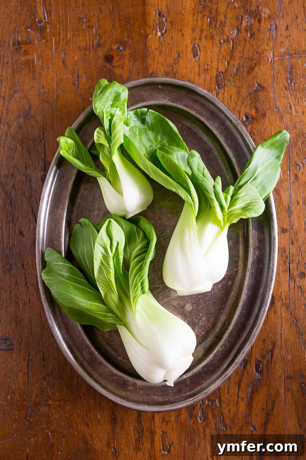 Blazing Pork Noodle Delight 3 Fresh, vibrant baby bok choy leaves arranged on a platter, ready for preparation.