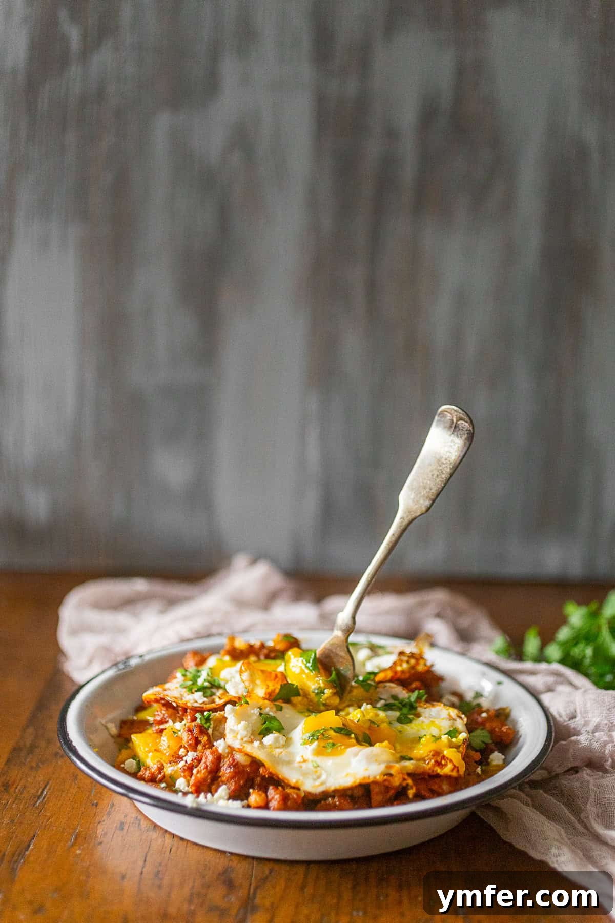Chorizo Fiesta Hash 3 Chorizo Breakfast Hash in a rustic dish with a fork, showing the texture of the plantains and chorizo.