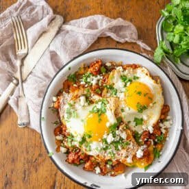 A serving of Chorizo Breakfast Hash with a fried egg and fresh cilantro.
