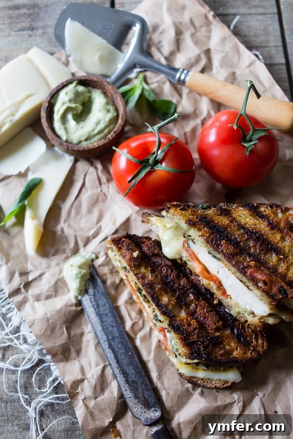 Sizzling Chicken Pesto Panini 2 Perfectly grilled chicken pesto panini with melted provolone cheese, ready for a delicious meal.