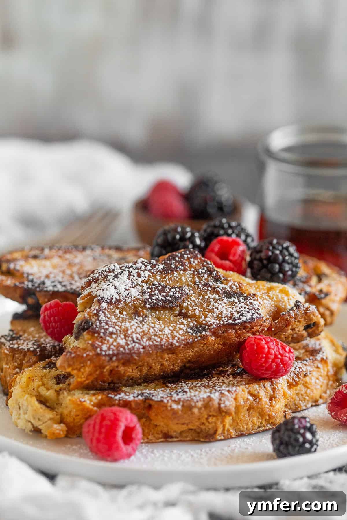 Emerald Isle French Toast 3 Close-up of a stack of Irish Soda Bread French Toast, generously topped with powdered sugar.