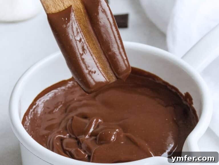 Decadent Chocolate Custard 12 A spoon tests the creamy texture of the finished chocolate custard in a pot.