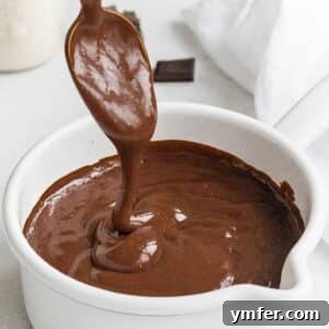 Decadent Chocolate Custard 9 A serving of chocolate custard in a white pot, garnished with a spoon.