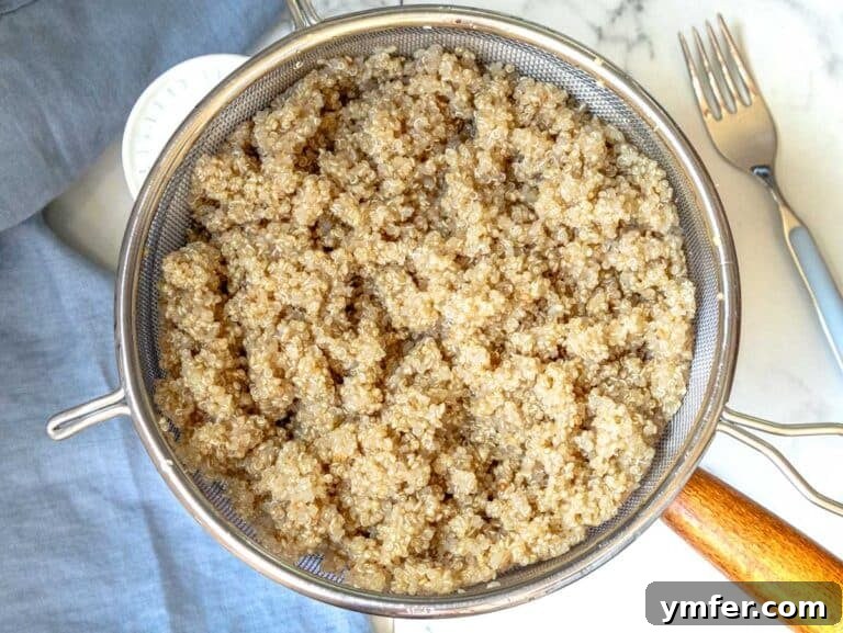 Vibrant Quinoa Bowl 10 Draining cooked quinoa in a fine-mesh sift over a pot for perfect texture.