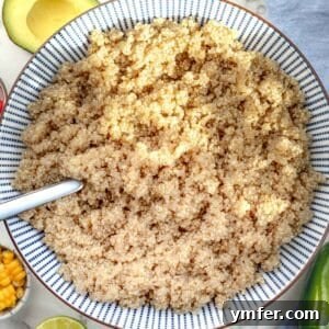 Cooked quinoa in a blue bowl with a silver spoon, highlighting its ideal texture.