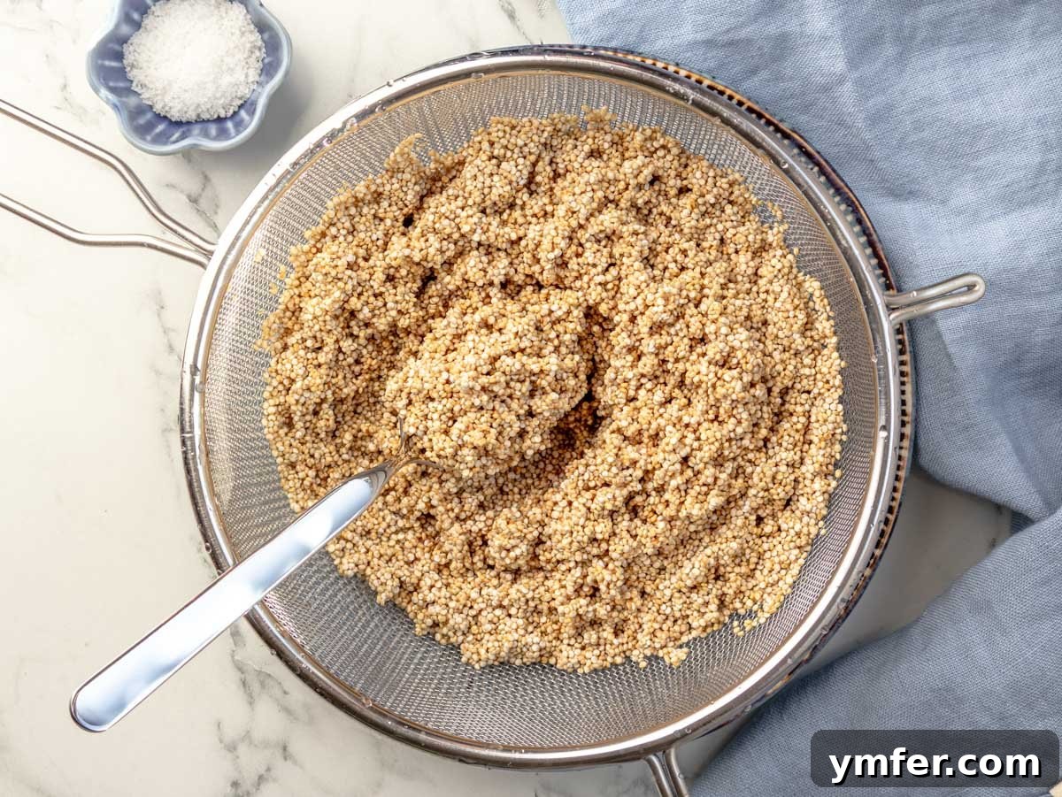 Mastering Perfectly Cooked Quinoa 6 Rinsed quinoa in a fine-mesh sieve, demonstrating the proper preparation step.