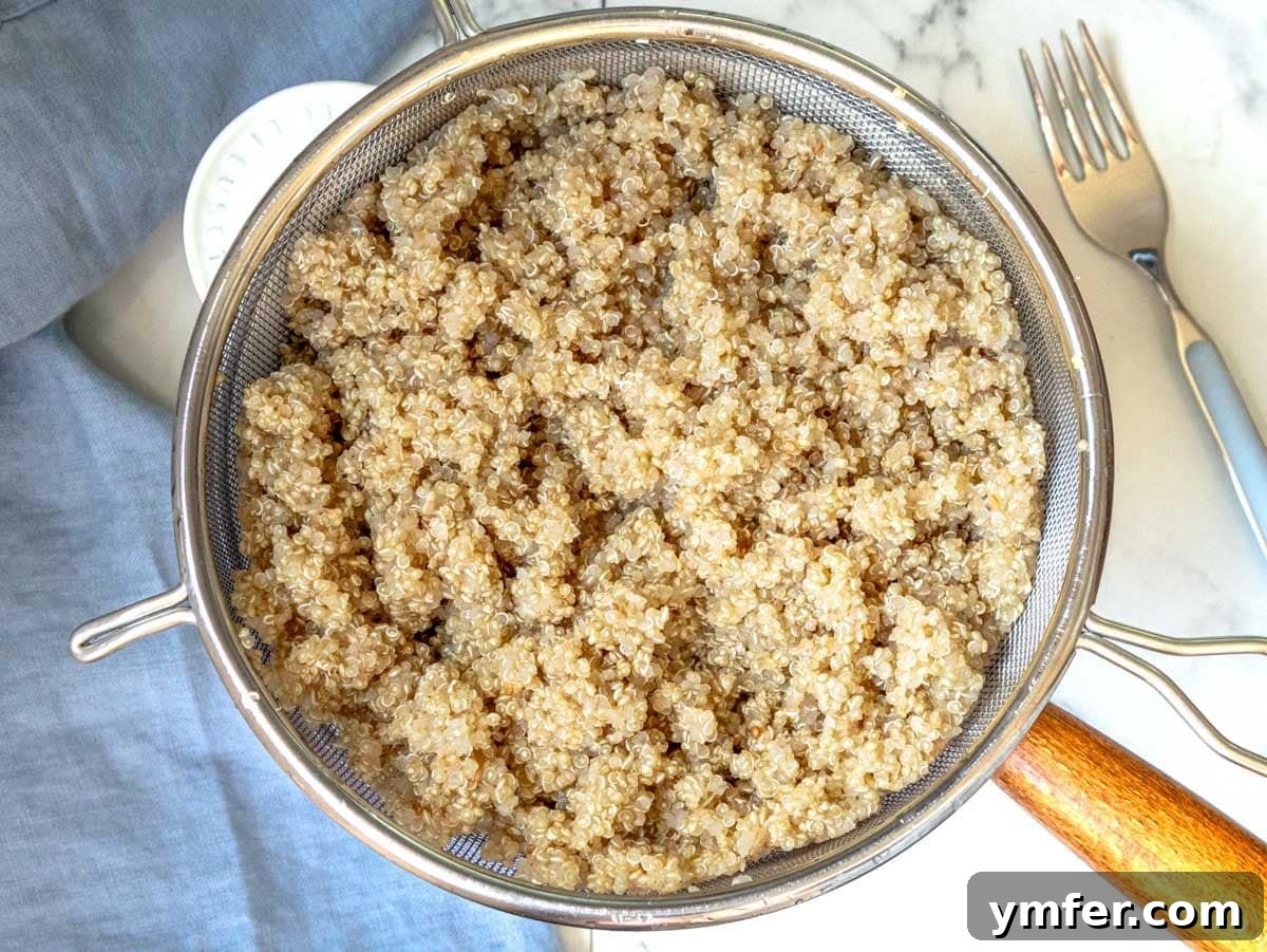Mastering Perfectly Cooked Quinoa 8 Draining cooked quinoa in a fine-mesh sieve over a pot, allowing it to steam dry.