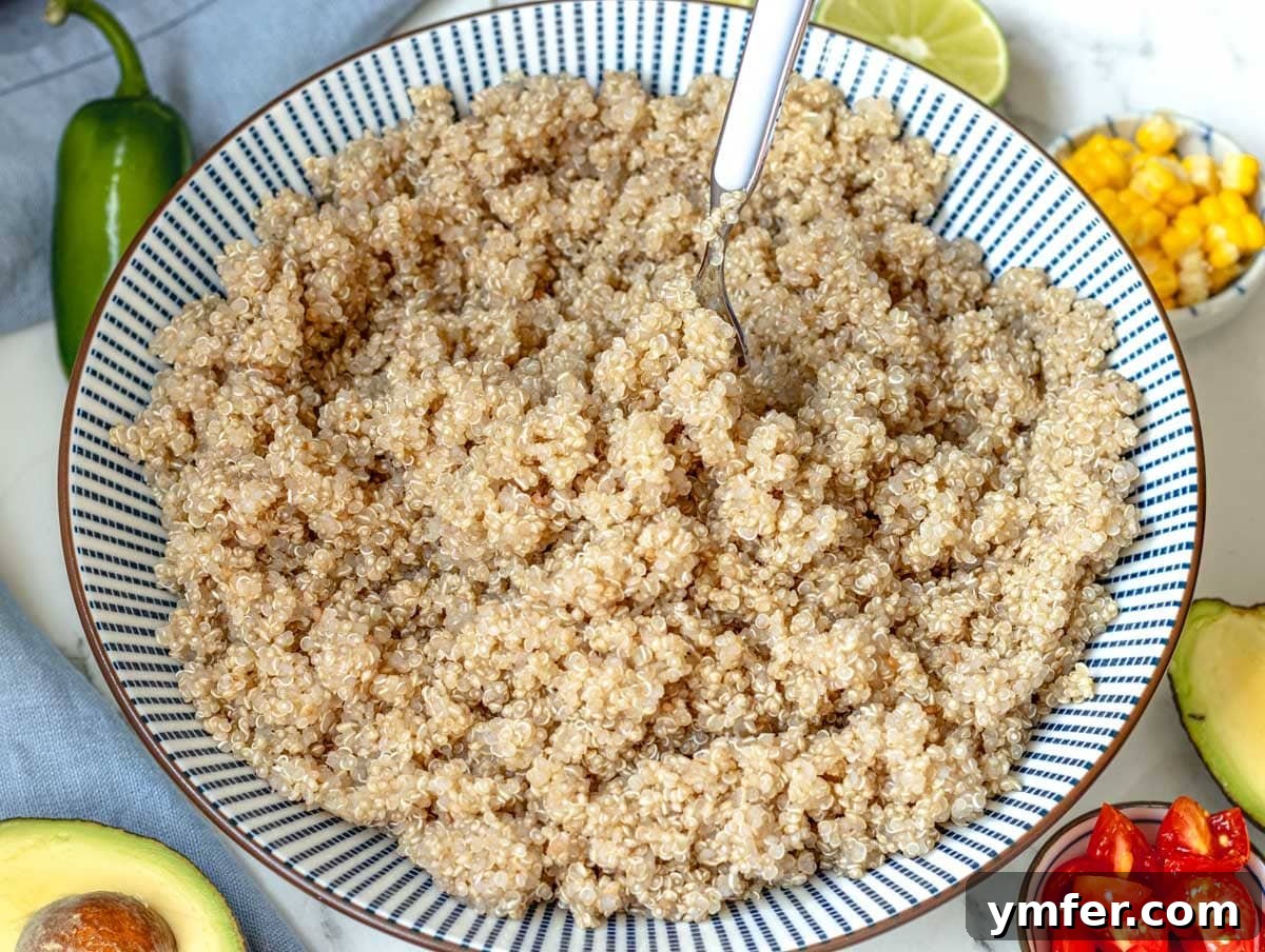 Mastering Perfectly Cooked Quinoa 9 Cooked quinoa served in a blue bowl with avocado on the side, highlighting its light and fluffy texture.