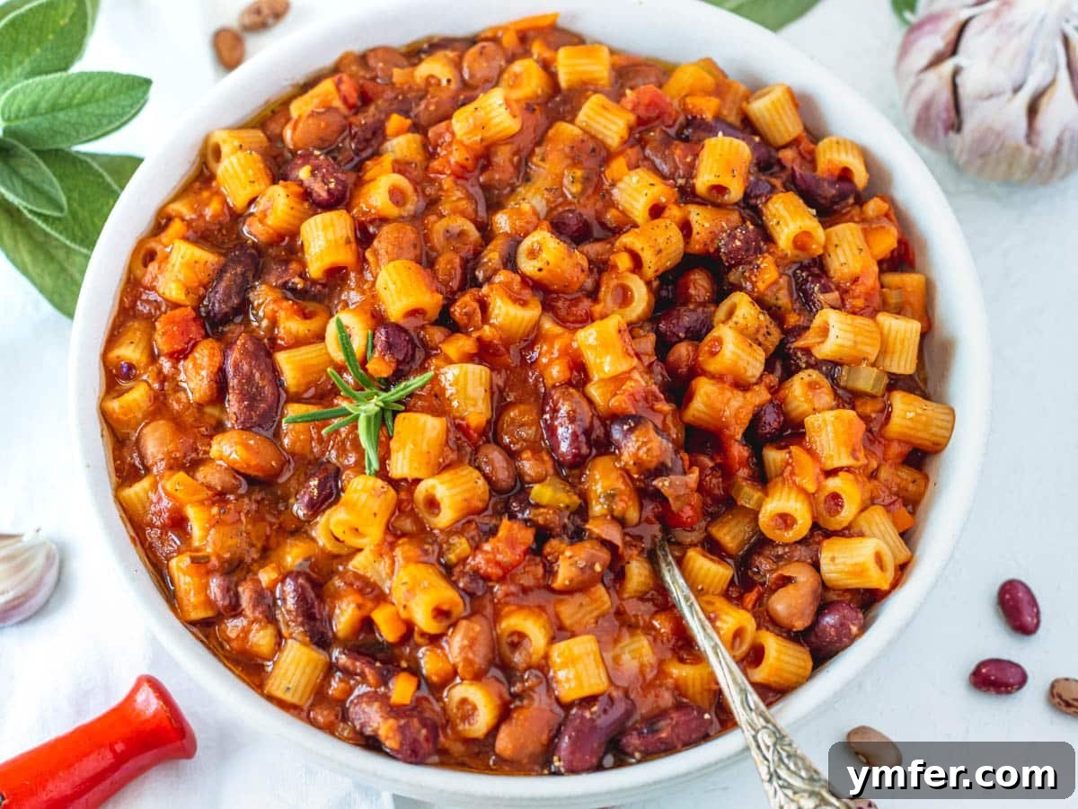 30 Dutch Oven Feasts 13 Pasta e Fagioli with a silver spoon and fresh rosemary