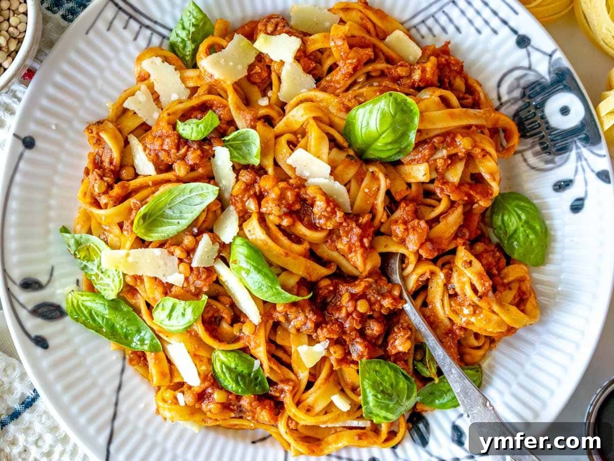 30 Dutch Oven Feasts 17 Lentil Bolognese with fresh basil, parmesan cheese and a fork