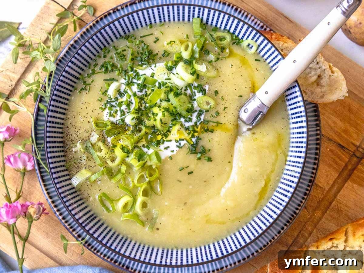 30 Dutch Oven Feasts 3 potato leek soup with a white spoon and garlic bread on the side