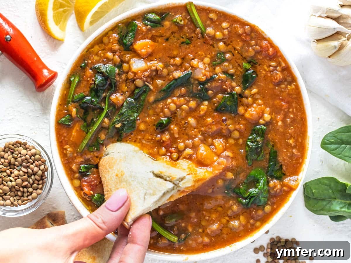 30 Dutch Oven Feasts 21 Easy lentil vegetable soup with hand holding pita bread