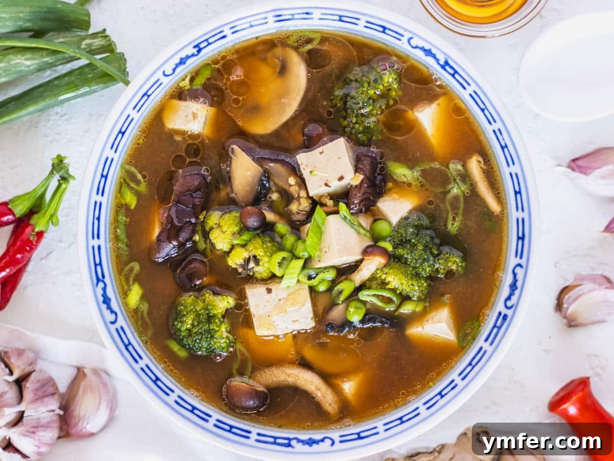 30 Dutch Oven Feasts 28 Tofu soup recipe in a blue bowl with garlic on the side