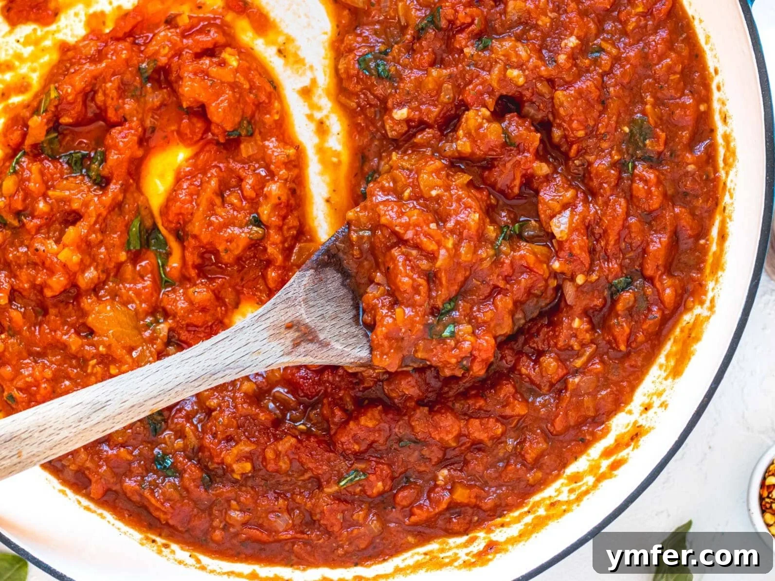 30 Dutch Oven Feasts 31 Marinara sauce in a skillet with a wooden spoon