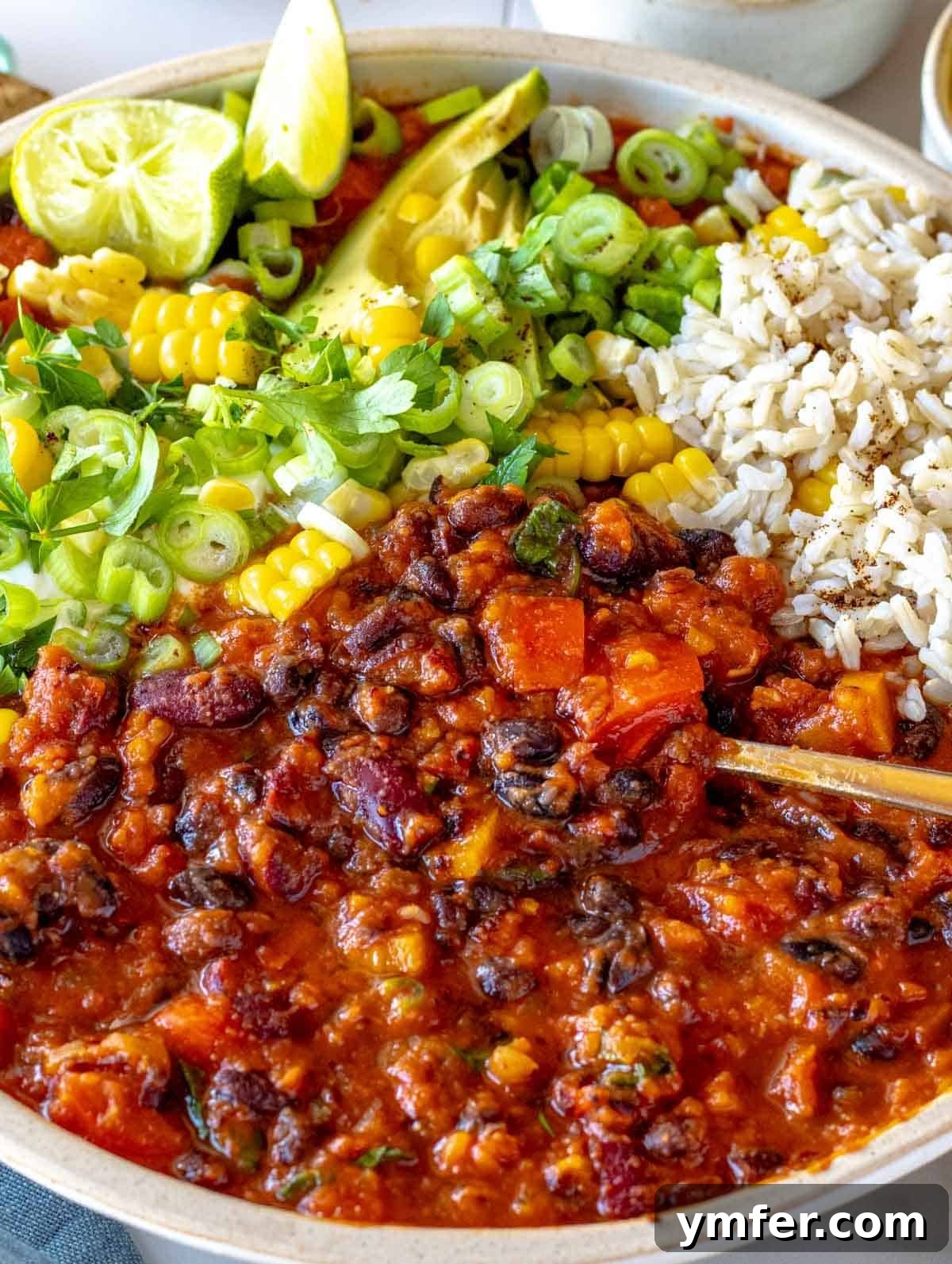 Hearty Veggie Chili 2 Vegetarian chili with brown rice, avocado and lime in a bowl