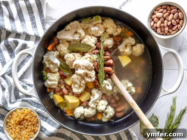 potatoes, cauliflower, and beans added to the pot