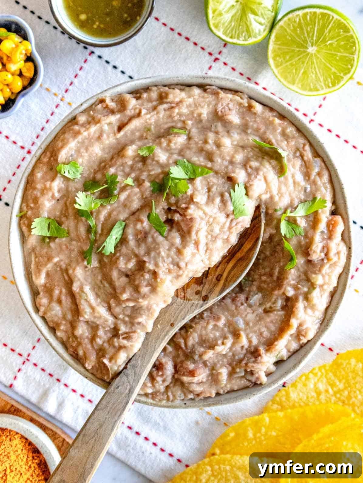 Savory Bean Mash 2 Refried beans with fresh cilantro garnish and a wooden spoon, ready to be served