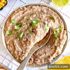 Refried beans with cilantro and a wooden spoon