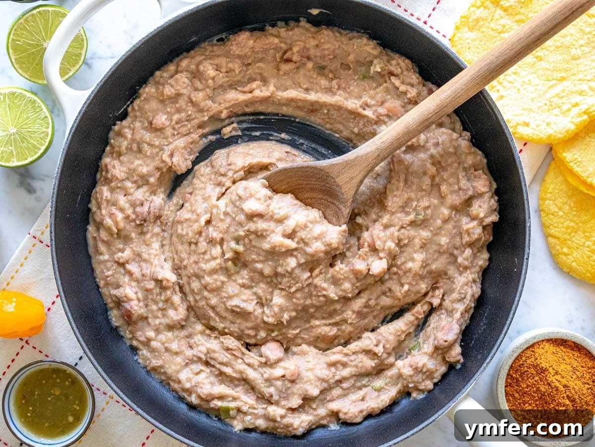 Savory Bean Mash 3 Refried beans simmering in a cast iron skillet, showcasing their rich texture