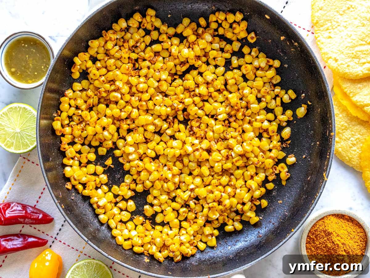 Crispy Topped Tortilla Delights 7 Sizzling sautéed corn with taco seasoning in a hot skillet, exhibiting a beautiful char and golden hue.