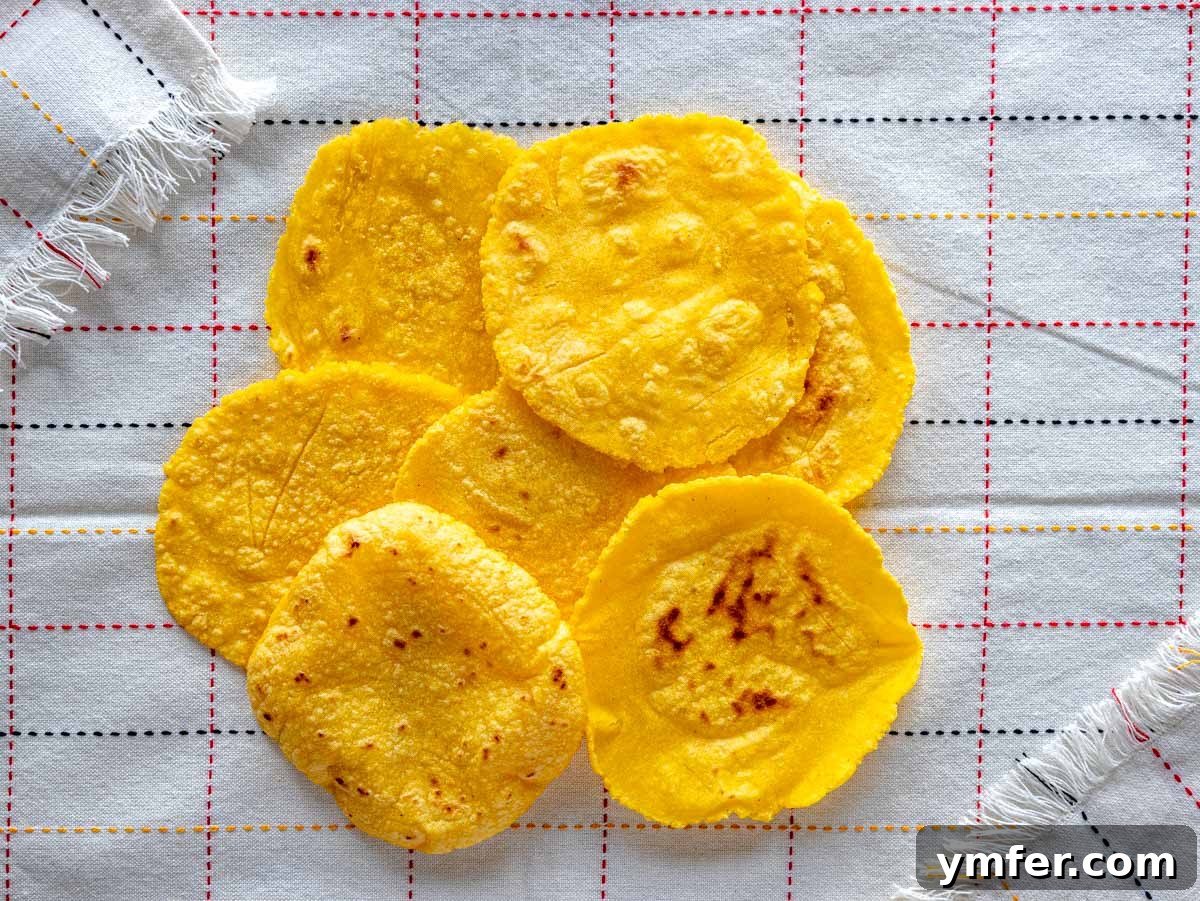 Handcrafted Corn Wraps 10 A stack of freshly cooked homemade corn tortillas wrapped in a kitchen cloth to keep warm