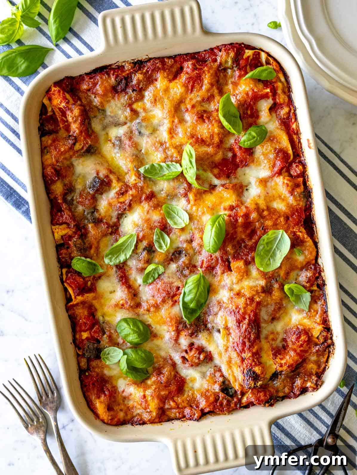 Garden Lasagna 2 A large baking dish filled with a beautifully baked vegetable lasagna, topped with golden-brown melted cheese and fresh herbs, ready to be served.