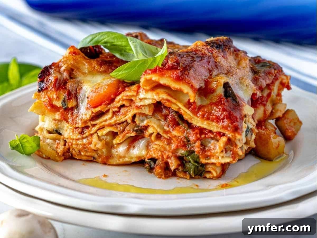 Garden Lasagna 3 A perfectly portioned slice of vegetable lasagna on a white plate, showcasing its distinct layers of pasta, vibrant vegetables, and creamy cheese.