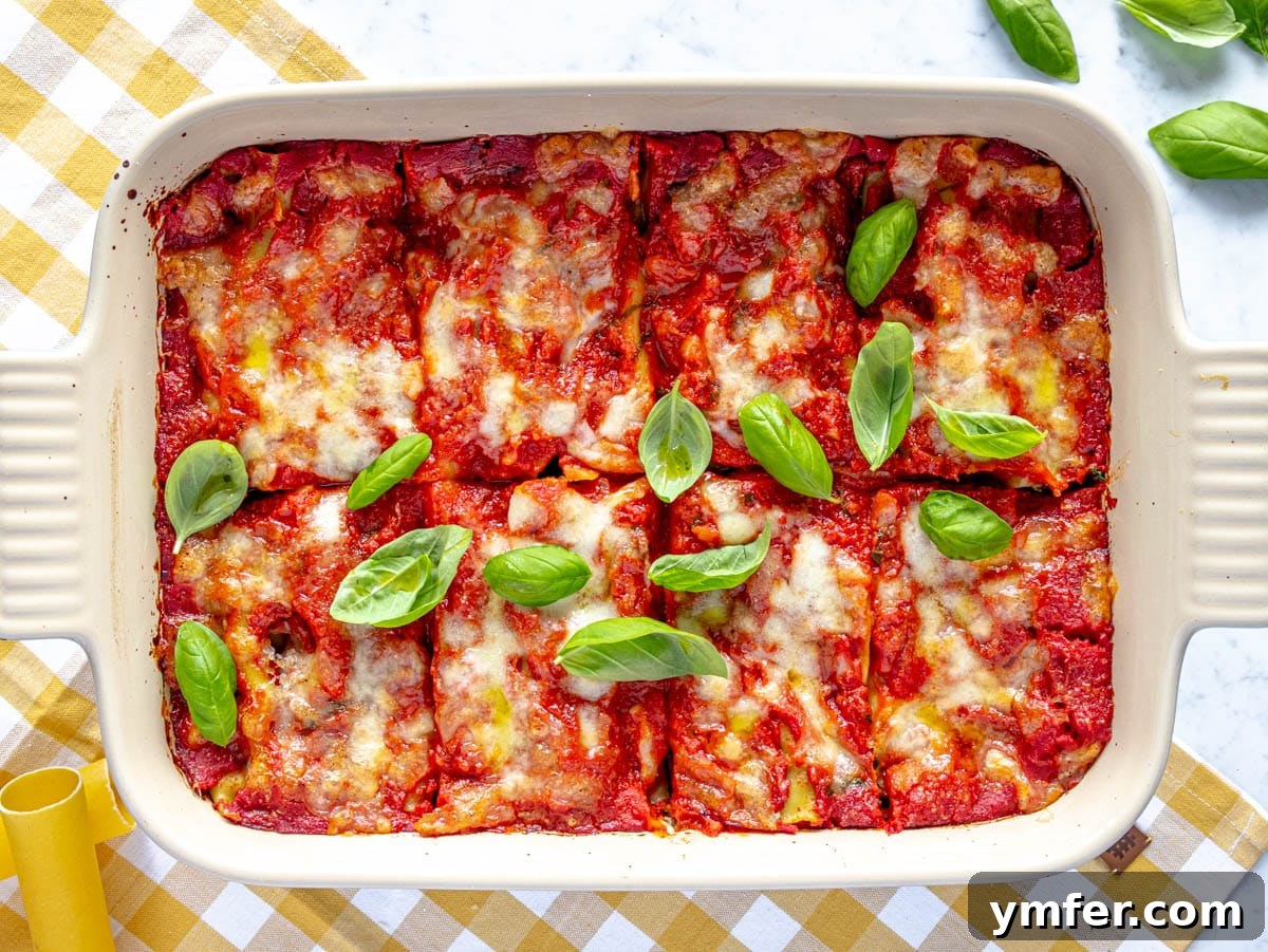 Hearty Stuffed Pasta Bake 10 Freshly baked cannelloni (or manicotti) dish, removed from the oven, bubbling with melted cheese and sauce, garnished with vibrant fresh basil.
