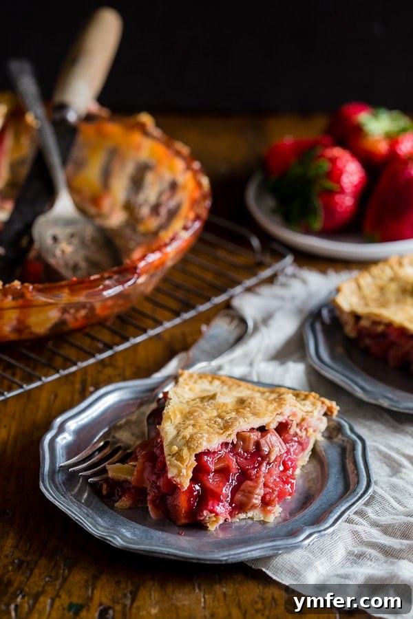 A perfectly baked homemade strawberry rhubarb pie, showcasing its golden-brown, flaky crust and vibrant filling.