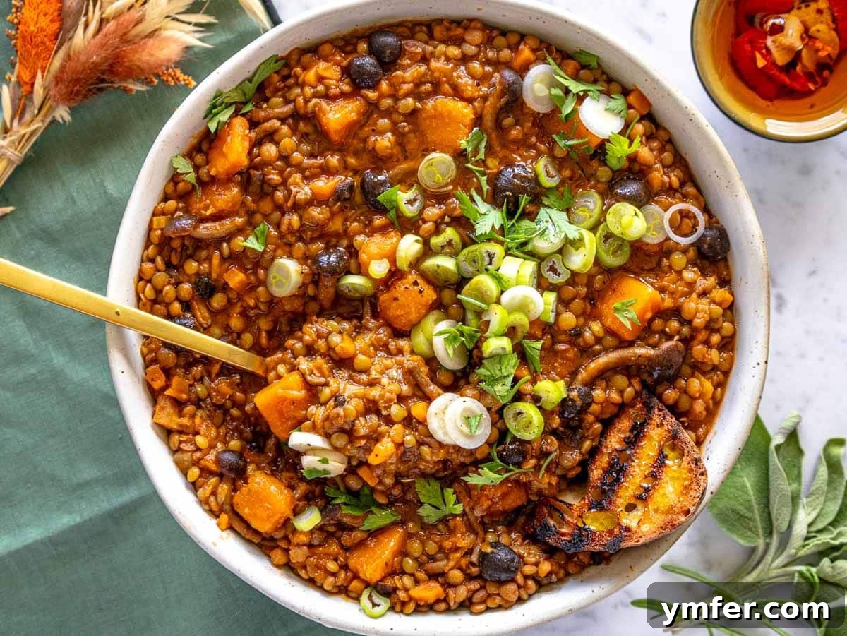 12 Cozy Butternut Squash Dishes 6 Thick and earthy lentil stew served in a bowl with a golden spoon.