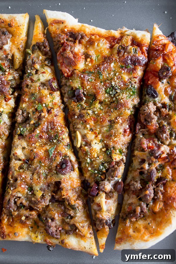 Robust Puttanesca Beef Pizza 2 Beef Puttanesca Pizza sliced on a sheet pan.