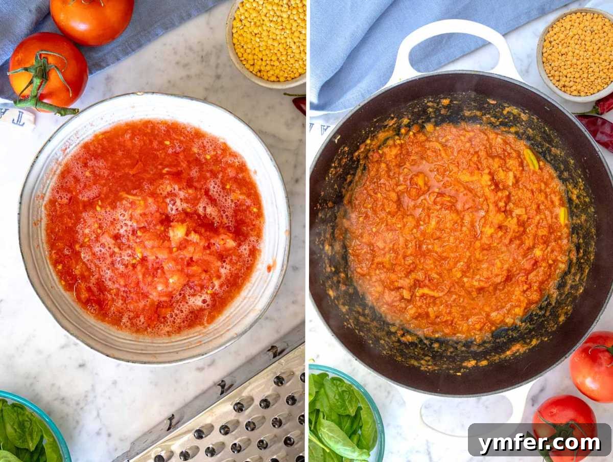 Freshly grated tomatoes being added to the spiced onion and garlic flavor base in a cooking pot, creating a rich red hue.