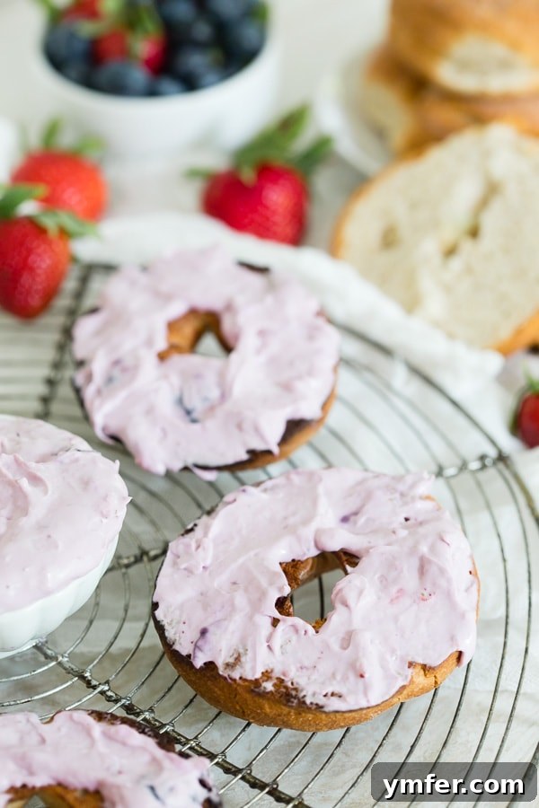 Creamy Berry Indulgence 4 A freshly toasted bagel generously topped with homemade roasted berry cream cheese, garnished with fresh berries.