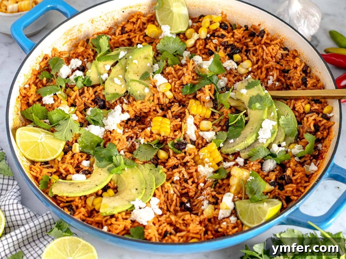Zesty Fiesta Rice 4 Close-up of Mexican rice in a blue skillet with a golden spoon, highlighting the texture
