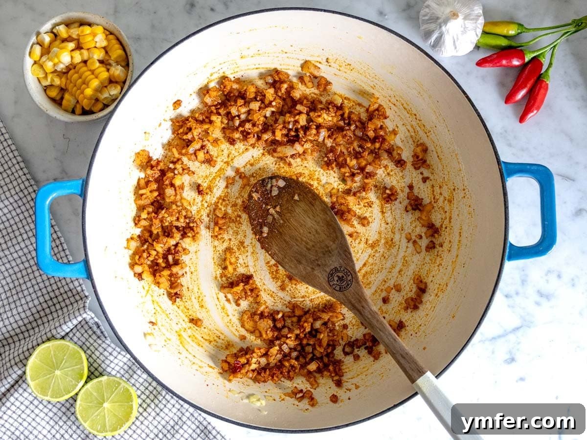 Zesty Fiesta Rice 6 Flavor base with sautéed onion, garlic, and spices in a skillet
