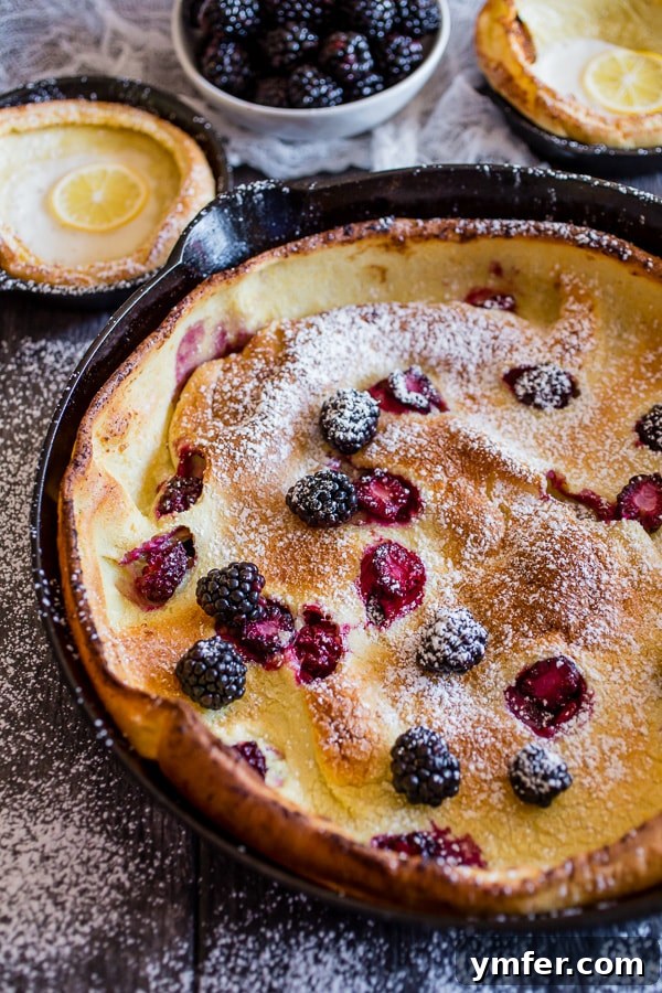Blackberry Lemon Dutch Baby dusted with powdered sugar, ready to serve.