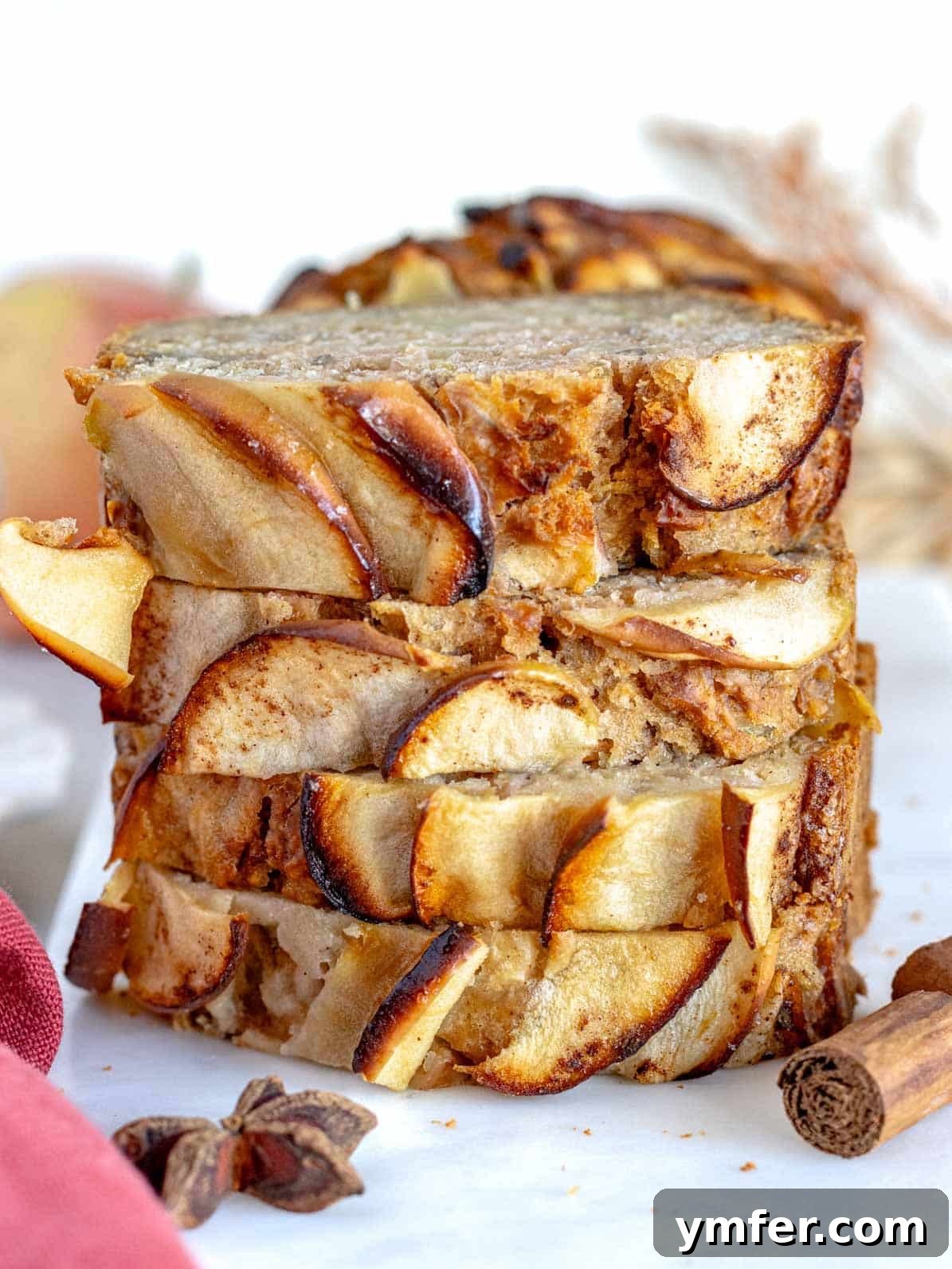 Healthy apple bread slices stacked on a cutting board, showcasing its moist texture and apple chunks