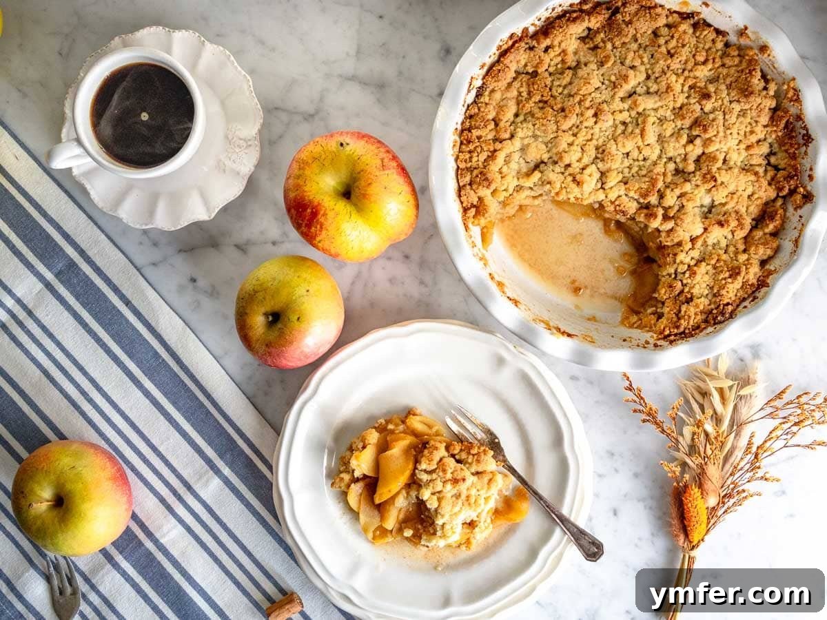 Golden Apple Crumble Perfection 6 Apple crumble with a portion on a white plate and a cup of coffee