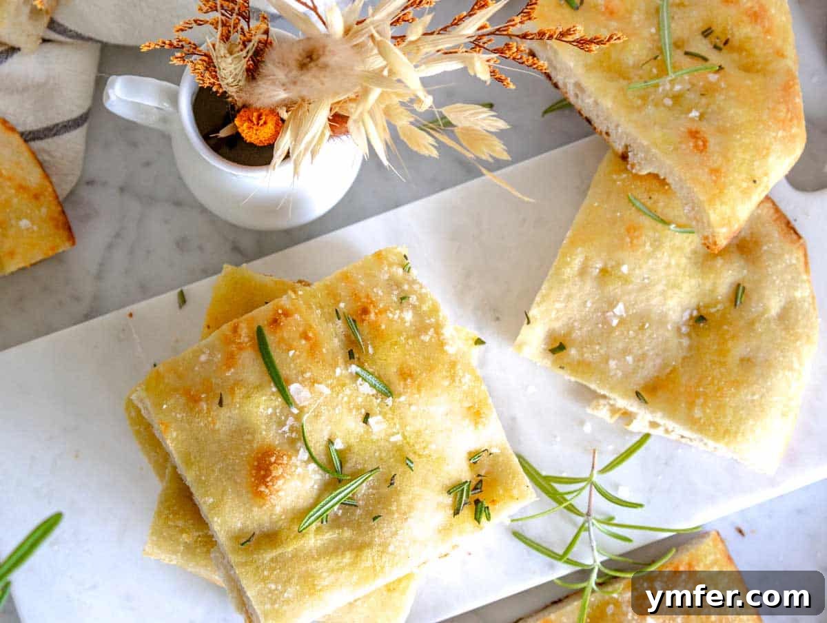 Golden Olive Oil Flatbread 14 schiacciata cut into squares on a white cutting board.