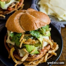 Baja burger on a plate topped with cilantro, crispy onions, and avocado.
