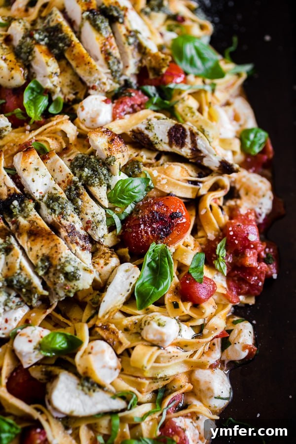 Fresh Caprese Pesto Chicken Pasta 3 Pesto Chicken Caprese Pasta on a large platter. The dish is presented beautifully, highlighting the vibrant colors of the ingredients.