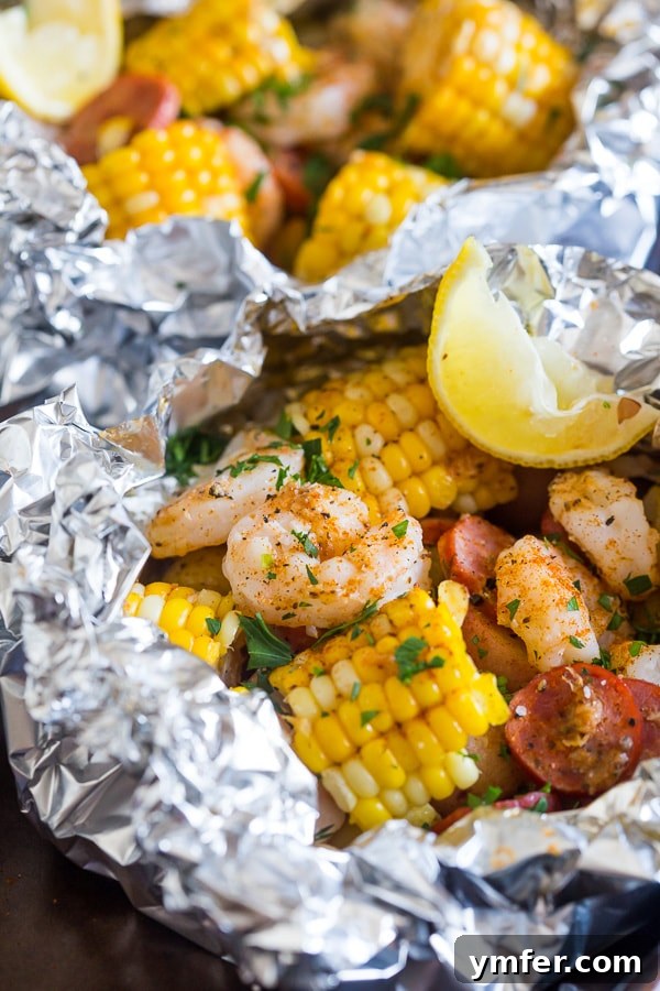 Corn and shrimp inside low country boil foil packets, showing a delightful meal ready to eat.