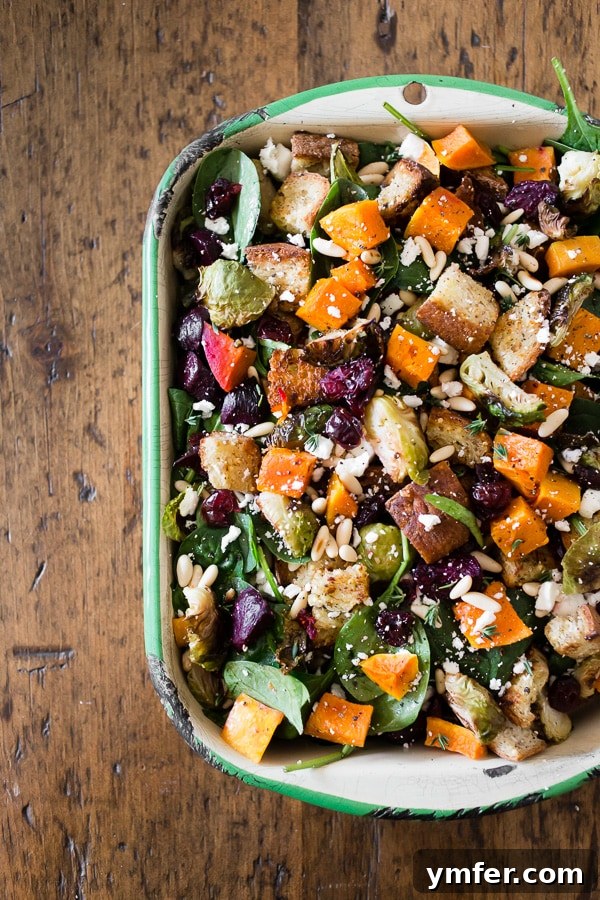 Autumn Harvest Panzanella 2 A vibrant Fall Panzanella Salad in a large serving dish, showcasing roasted vegetables, toasted bread, cranberries, pine nuts, and feta cheese, drizzled with vinaigrette.